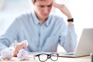 marketer crumping papers at his desk